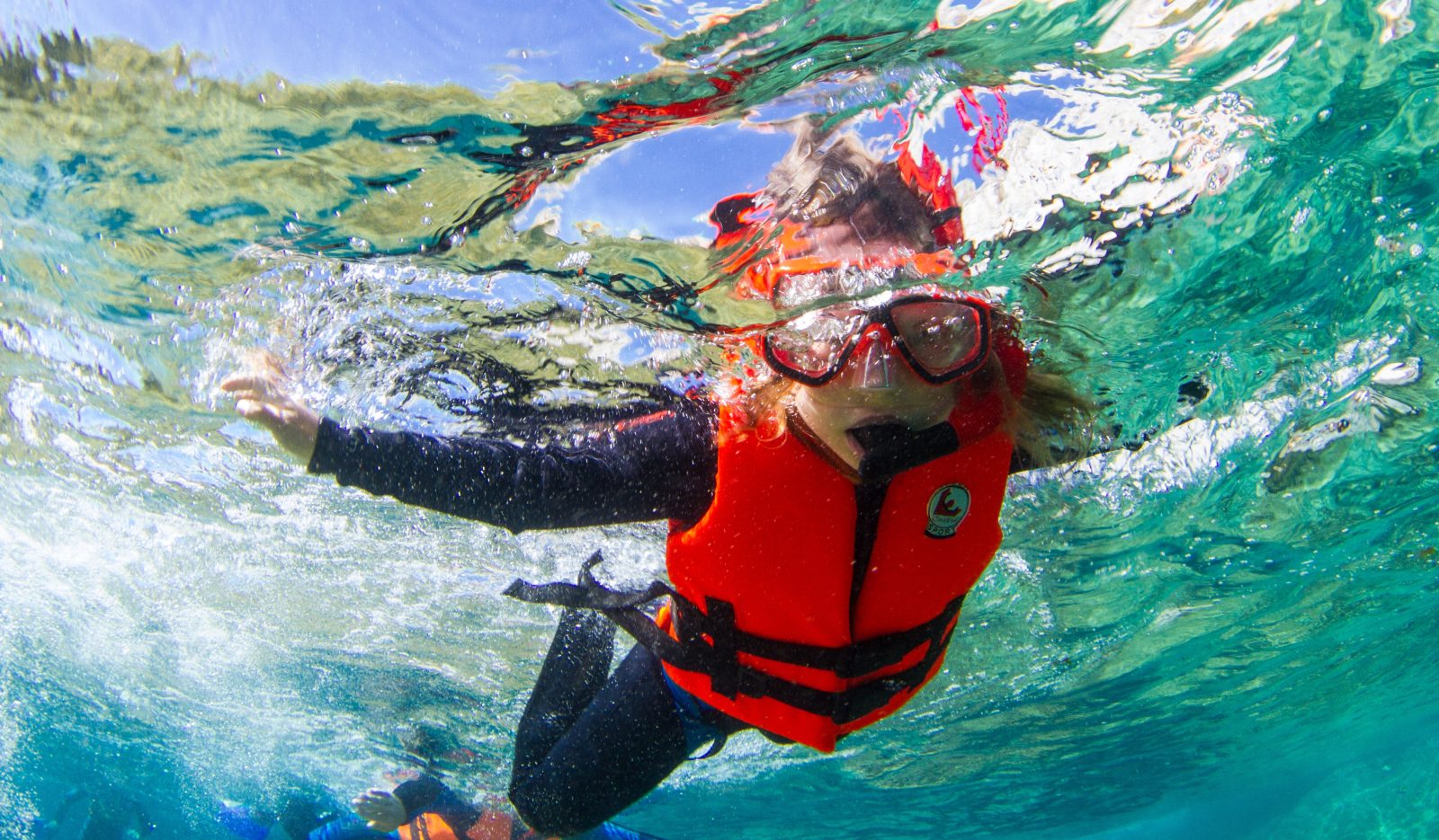 Snorkeler with mask and life vest floating in the clear turquoise water of Cabo Pulmo Snorkeler with mask and life vest floating in the clear turquoise water of Cabo Pulmo